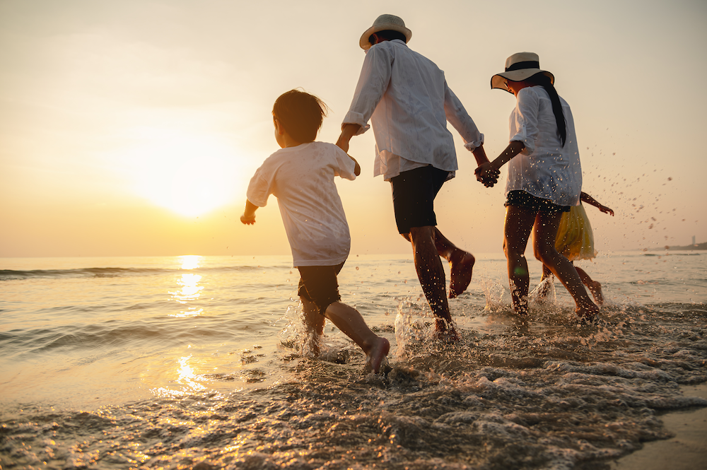 Family running on the beach.